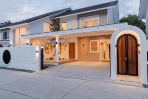 a house with a washing machine in front of it at White Wood Family Villa, 5 Kingbeds, 12 mins airport in Chiang Mai