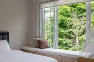 a window seat in a room with two beds at White Wood Family Villa, 5 Kingbeds, 12 mins airport in Chiang Mai +72 photos