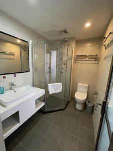 une salle de bain avec douche, lavabo et toilettes dans l'établissement Jun Hotel Hunan Yongzhou Ningyaun Shundi Plaza, à Ningyuan