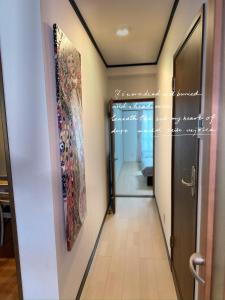 a hallway with a painting on the wall next to a door at HYGGE HOUSE Tabibitonoie - Vacation STAY 33409v in Kashiwa +1 photo