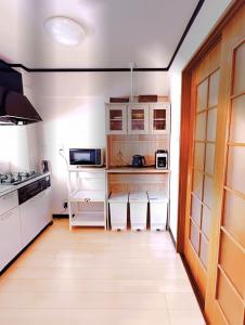 a kitchen with white cabinets and a wooden floor at HYGGE HOUSE Tabibitonoie - Vacation STAY 33409v in Kashiwa