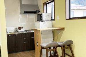 a small kitchen with two bar stools and a microwave at Wine Inn Tomu - Vacation STAY 42199v in Katsunuma +17 photos