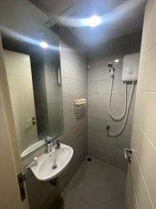 泗水Family Apartemen Near Pakuwon Mall的带水槽和带镜子的淋浴的浴室