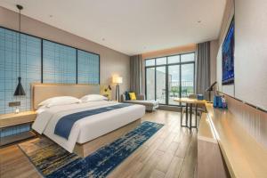 a bedroom with a large bed and a large window at Echarm Hotel Fangchenggang Qisha in Fangcheng +260 photos