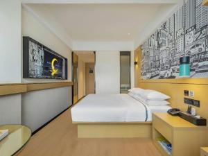 ein Schlafzimmer mit einem großen weißen Bett und einem Schreibtisch in der Unterkunft City Comfort Inn Fangchenggang Qisha in Fangchenggang