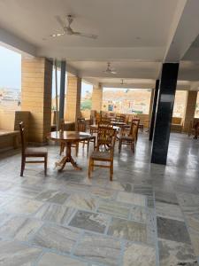a restaurant with wooden tables and chairs in a room at Desert offbit luxurious camp in Jaisalmer