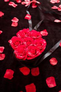 a bouquet of red roses on a table with hearts at La Maison Coquine in Béthune +15 photos