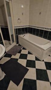 a bathroom with a tub and a black and white checkered floor at Listowel Town in Listowel