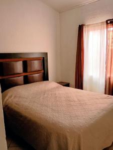 a bedroom with a large bed and a window at Casa a una cuadra de la playa in Ensenada