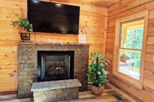 a living room with a fireplace with a flat screen tv at Misty Mountain View - 2 bedroom cabin in Glade