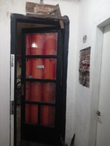 une porte vers une pièce avec des extincteurs rouges dans l'établissement Costagchu187, à Gualeguaychú