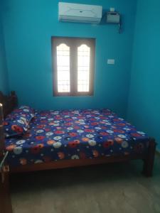Un dormitorio azul con una cama con flores. en Uthresh Guest House, en Tiruvannāmalai 11 fotos más
