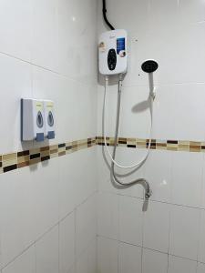 a bathroom with a shower with a phone on the wall at Rest And Relax Hostel in Ban Mo Nae