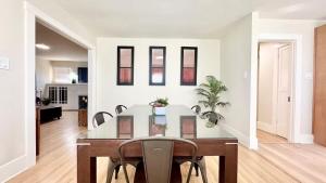 een eetkamer met een glazen tafel en stoelen bij Iconic 2BR Bungalow, Short Walk to SJSU, with Parking in San Jose