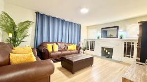 een woonkamer met lederen meubels en een open haard bij Iconic 2BR Bungalow, Short Walk to SJSU, with Parking in San Jose