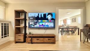 een woonkamer met een flatscreen-tv aan de muur bij Iconic 2BR Bungalow, Short Walk to SJSU, with Parking in San Jose +36 foto's