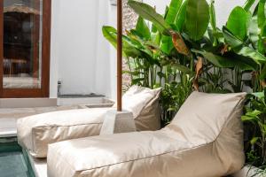 a living room with two white couches and plants at Anna Villa Pererenan in Canggu