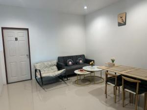 a living room with a couch and a table at Rest And Relax Hostel in Ko Lanta