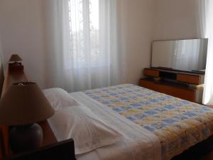 a bedroom with a bed and a flat screen tv at Apartment Petar in Lastovo