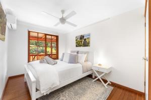 a white bedroom with a bed and a window at Picturesque Pet-Friendly Farm Stay, Central Tilba , Near Mystery Bay! in Central Tilba