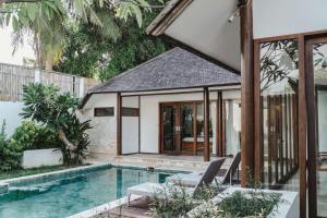 an external view of a house with a swimming pool at Ningaloo Villa in Gili Trawangan