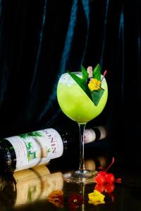 a drink in a martini glass next to a bottle at Kecho Legacy Hotel Hanoi & Spa in Hanoi