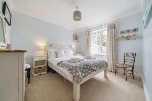 a bedroom with a bed and a chair and a window at Orchard House Docking in Docking