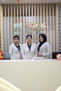 un gruppo di tre donne in piedi dietro un tavolo di Analynn Hotel a Ban Kohong Altre 78 foto