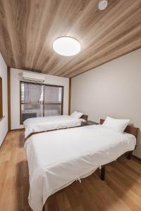 a large bedroom with two beds and a ceiling at 勝清居 大阪獨棟車庫民宿 千日前線新深江站2分一線直達 難波日本橋 全新裝修3LDk in Osaka