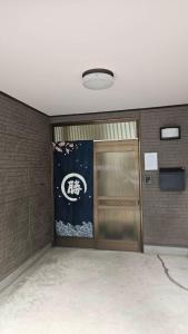 una habitación con una puerta y un cartel en la pared en 勝清居, en Osaka