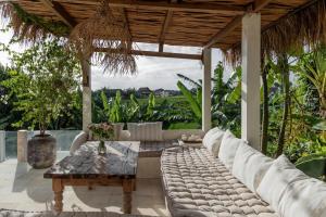 a living room with a couch and a table at BI Design House Canggu in Canggu +56 photos