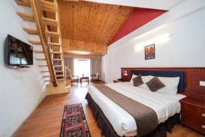 a bedroom with a bed and a wooden ceiling at Hotel Monal in Manāli