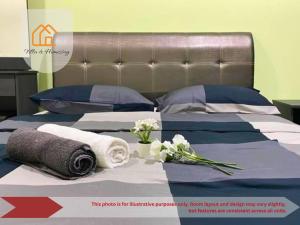 a bed with towels and flowers on top of it at The Cozy Spot SOHO Suite Cyberjaya in Cyberjaya +26 photos