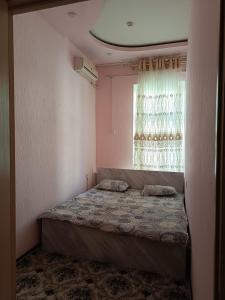 a bedroom with a bed in front of a window at Rakat Palace in Tashkent