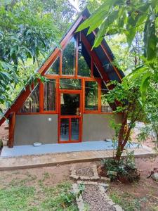 a house with glass doors in a forest at Ritigala Hideaway in Habarana
