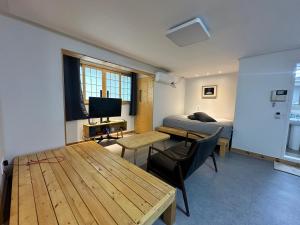 首尔Neovill的有两张床、一张桌子和一台电视的房间