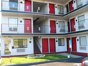 um edifício com portas vermelhas e escadas em Red Carpet Inn Williamstown em Williamstown