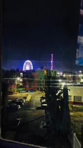 a parking lot with a ferris wheel in the background at Departamento moderno a un lado de la feria in Pachuca de Soto