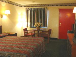 a hotel room with a bed and a table at Red Carpet Inn Williamstown in Williamstown