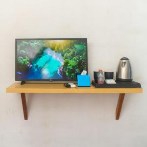 a flat screen tv sitting on a wooden shelf at Seaside Hotel in Gili Trawangan