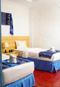 a hotel room with two beds and a red floor at Seaside Hotel in Gili Trawangan