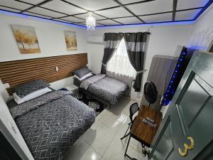 une chambre avec deux lits et un bureau et une fenêtre dans l'établissement Sunrise Haven Holiday Apartments Barbados, à Christ Church