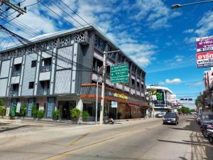 a building on a city street with a street sign at Grand Vissanu Hotel in Ban Pak Nam Pho