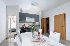 a white kitchen with a table with a bottle of wine at Apartments Jadranka in Lovište