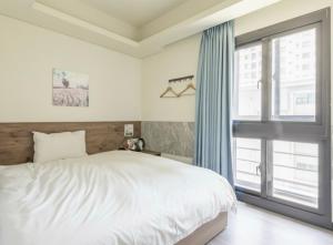 Un dormitorio con una cama y una ventana grande en 台中逢甲豐和立hotel商旅 台中出差統編可 台中團體訂房 台中國民旅遊卡 台中包層 台中包棟 電視可看youtube, en Taichung
