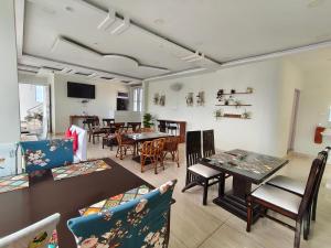a room with tables and chairs and a dining room at Gliders Inn- Curated by Sukhdev in Bīr