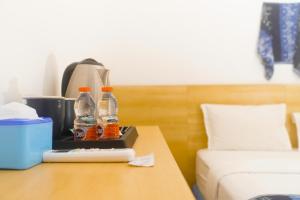 two bottles of soda on a table next to a bed at Seaside Hotel in Gili Trawangan