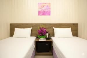 Dos camas una al lado de la otra en una habitación. en 台中逢甲豐和立hotel商旅 台中出差統編可 台中團體訂房 台中國民旅遊卡 台中包層 台中包棟 電視可看youtube, en Taichung