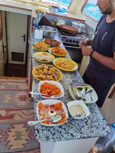 un hombre parado frente a un buffet de comida en رحلات بحرية دولفين وغواصة وجزر, en Hurghada