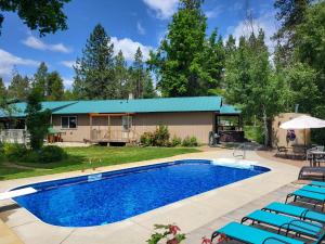 a swimming pool with chairs and a house at 5 acres, Pool, Hot-tub, Zipline, Firepit, Arcade, BBQ, Shuffleboard in Deer Park